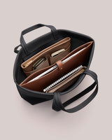 Open handbag with organized items including folders, notebook, and phone.