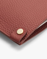 Textured leather corner with metal rivet detail.