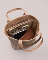 Open handbag with compartments holding notebook and items inside.
