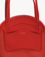 Close-up of a handbag with multiple straps and visible pocket stitching.