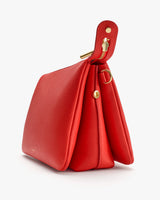 Side view of a structured handbag with gold accents.