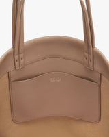 Round bag with a front pocket and two handles.