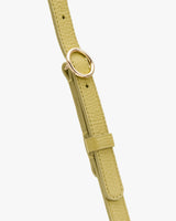 Close-up of a textured strap with a circular metal buckle.