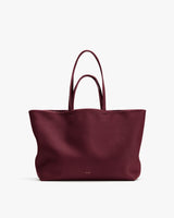 Large tote bag with double handles and subtle branding on the front.