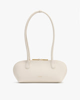 A handbag with long handles and a zip closure.
