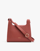 Leather shoulder bag with a wide strap and gold buckle.