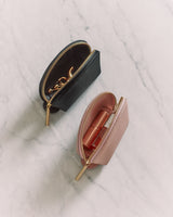 Two small makeup bags with zippers open, one showing contents.