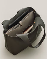 Handbag open with pens and a notebook inside