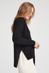 Woman in profile, looking down, adjusting her sleeve.