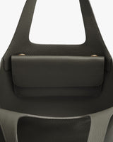 Close-up of a handbag with a front flap and handle
