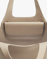 Close-up of a handbag with a textured surface and handles.