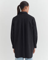 Person seen from behind wearing a long-sleeved shirt and jeans.