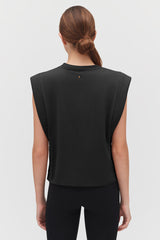 Woman facing away, wearing a top with a split back.