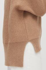 Person wearing a sweater and white pants, side view.