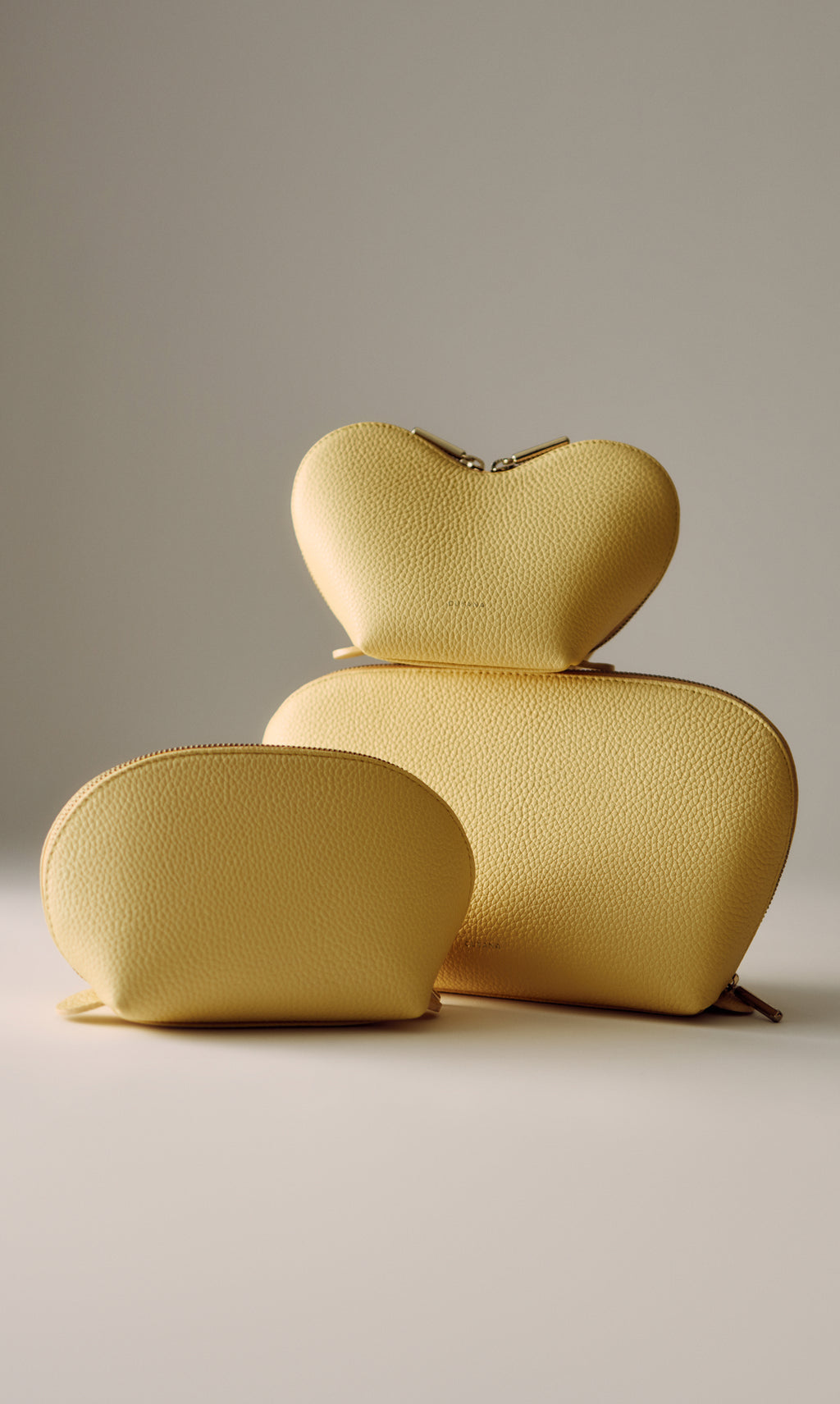 Three textured pouches in different shapes and sizes stacked together.
