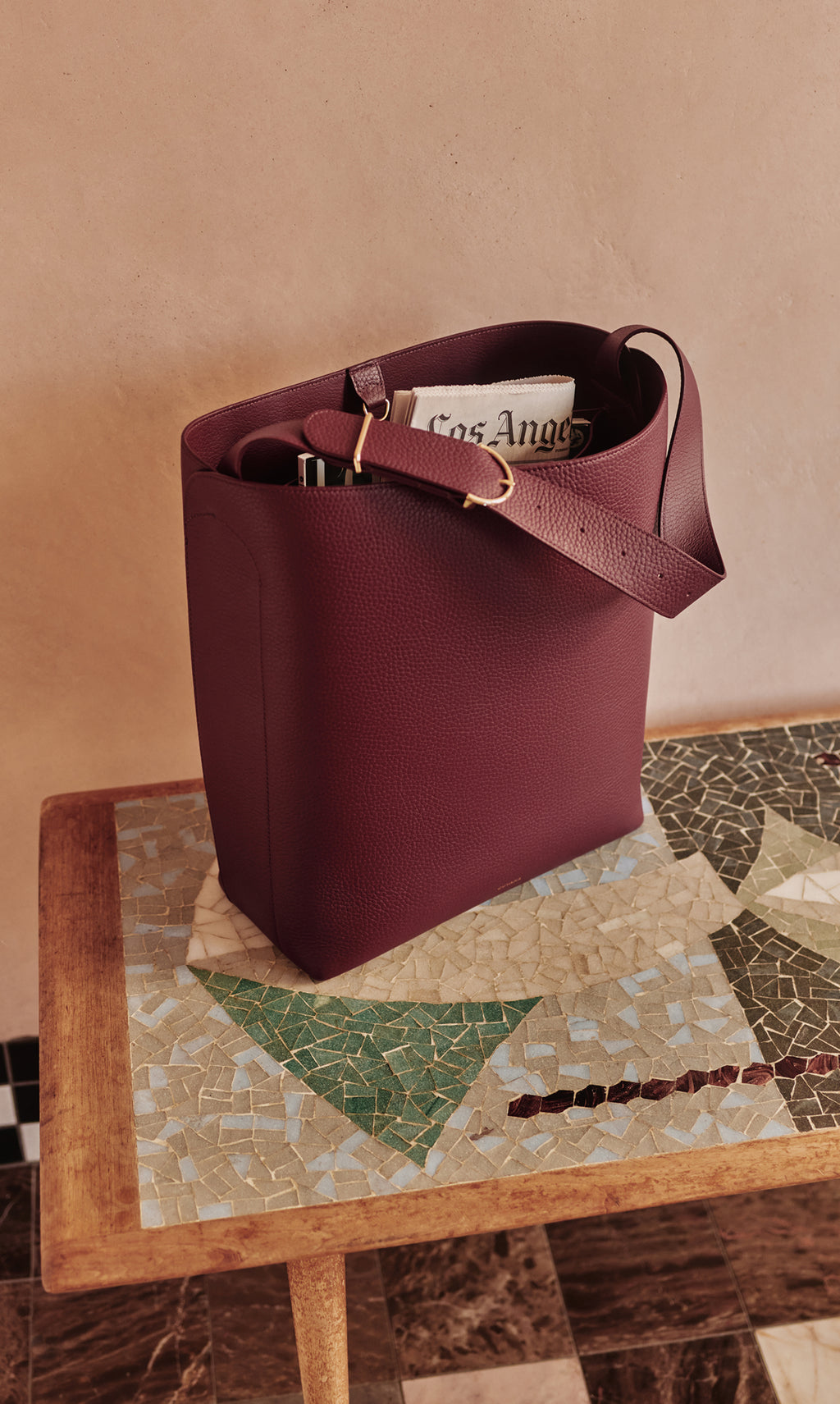Tote bag on table with newspaper and items inside