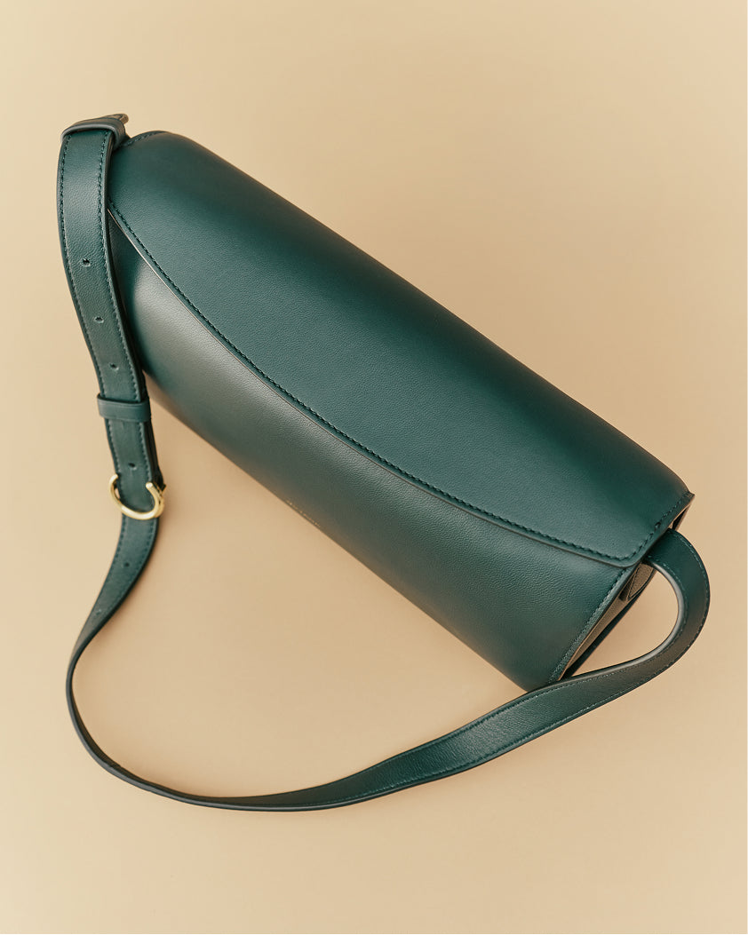 Sleek shoulder bag with adjustable strap on plain background