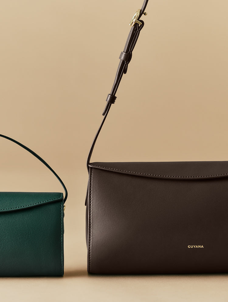 Two leather handbags on display with simple flap closures.