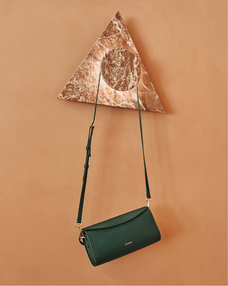 Handbag with strap suspended on marble-patterned triangle hanger