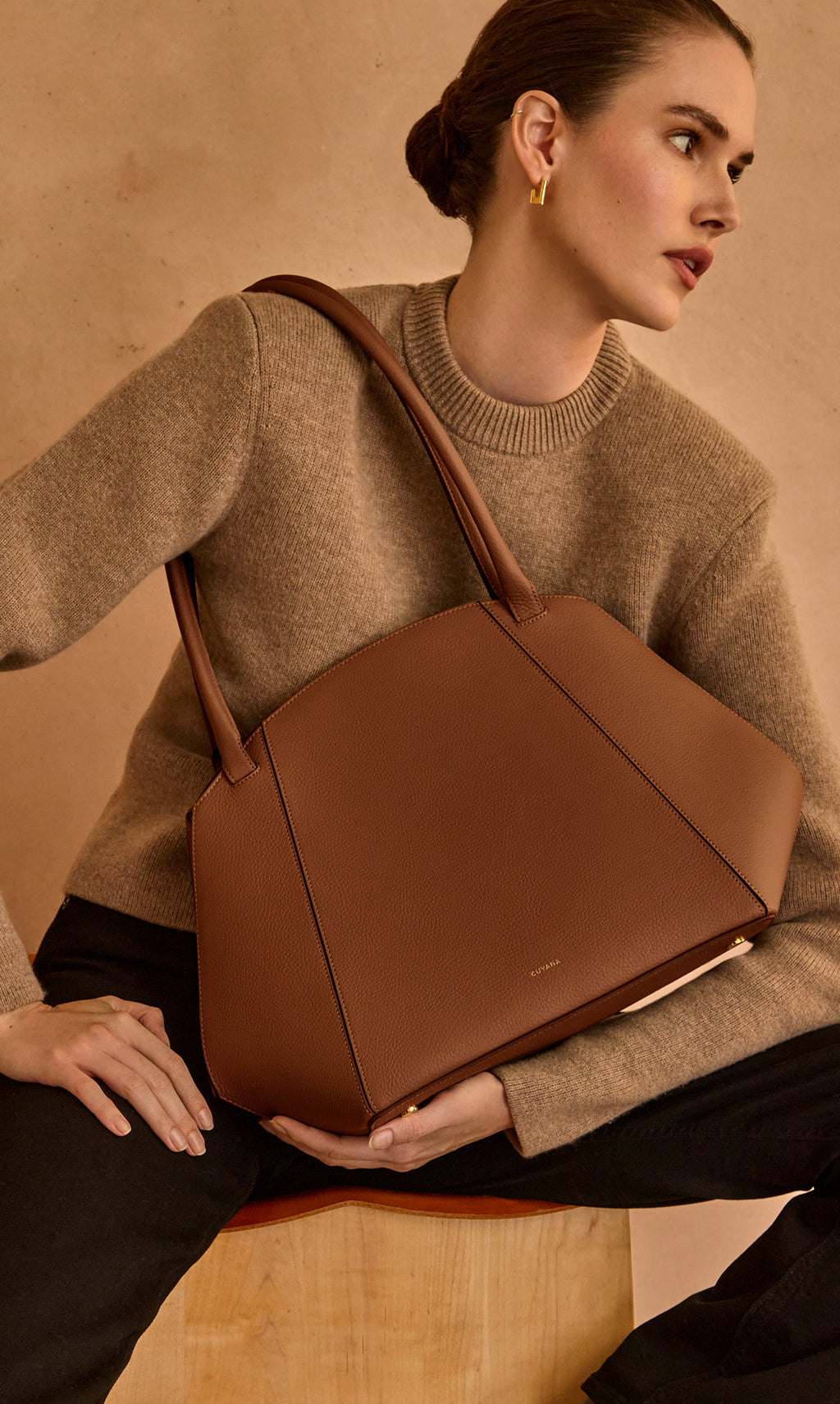 Person with large handbag sitting on a wooden block