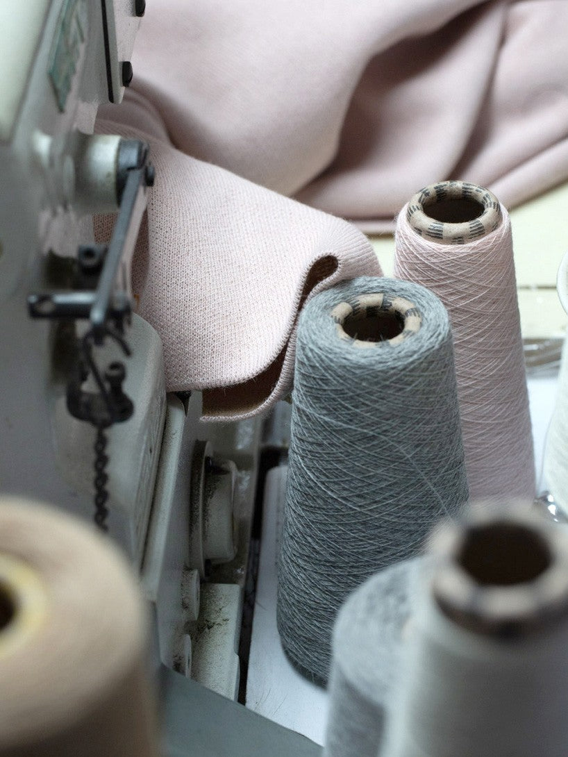 Sewing machine with multiple thread spools and fabric nearby.