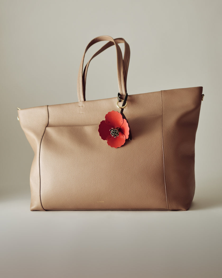 Large handbag with flower tag attached to the handle.