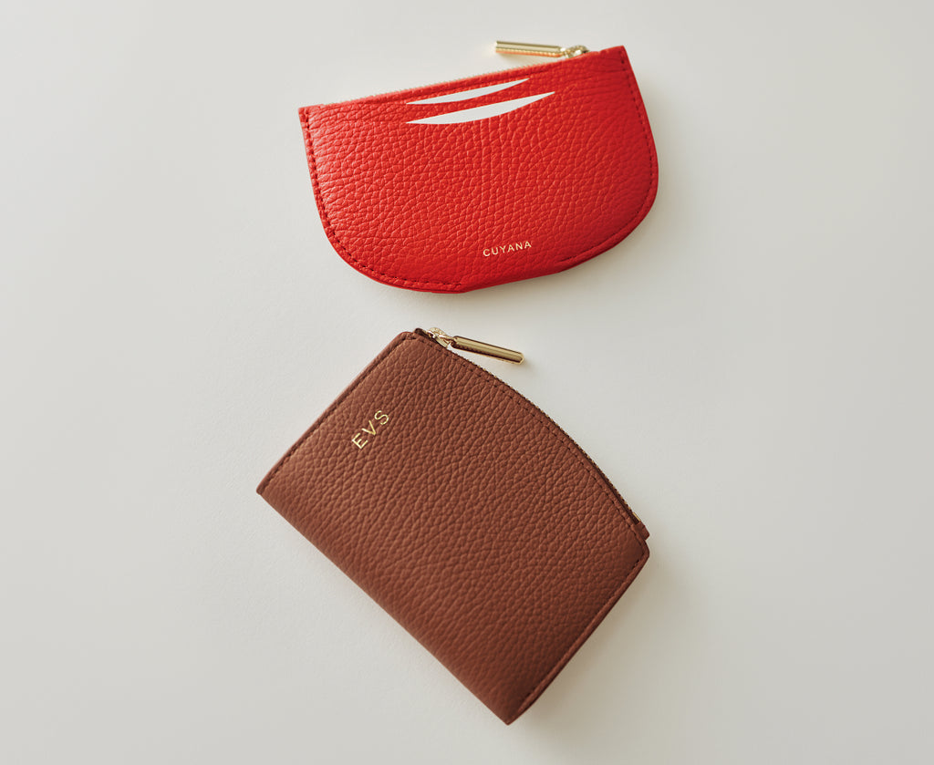 Two leather zippered pouches arranged on a plain surface.