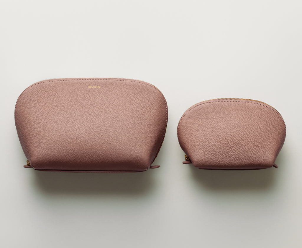 Two leather pouches, one larger than the other, side by side on a plain background.
