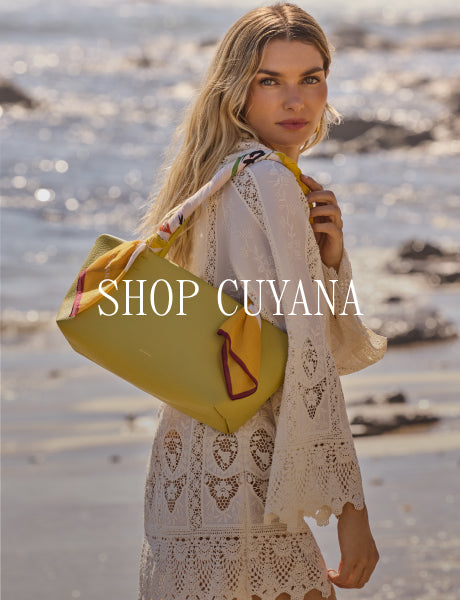 Woman at the beach holding a bag over her shoulder, text overlay says shop Cuyana.
