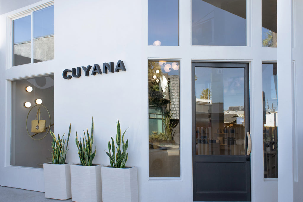 Storefront with large windows and a sign reading Cuyana above the entrance.