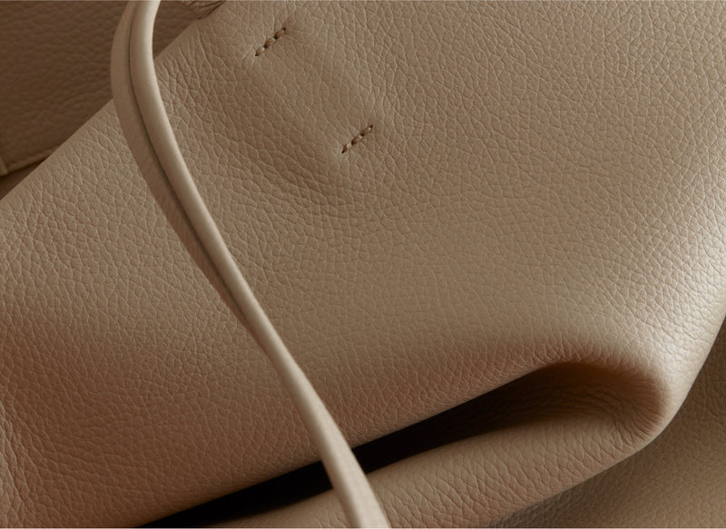 Close-up view of textured leather with a strap visible.
