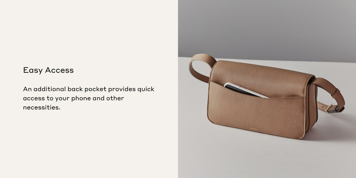Bag with strap and visible back pocket containing a phone.