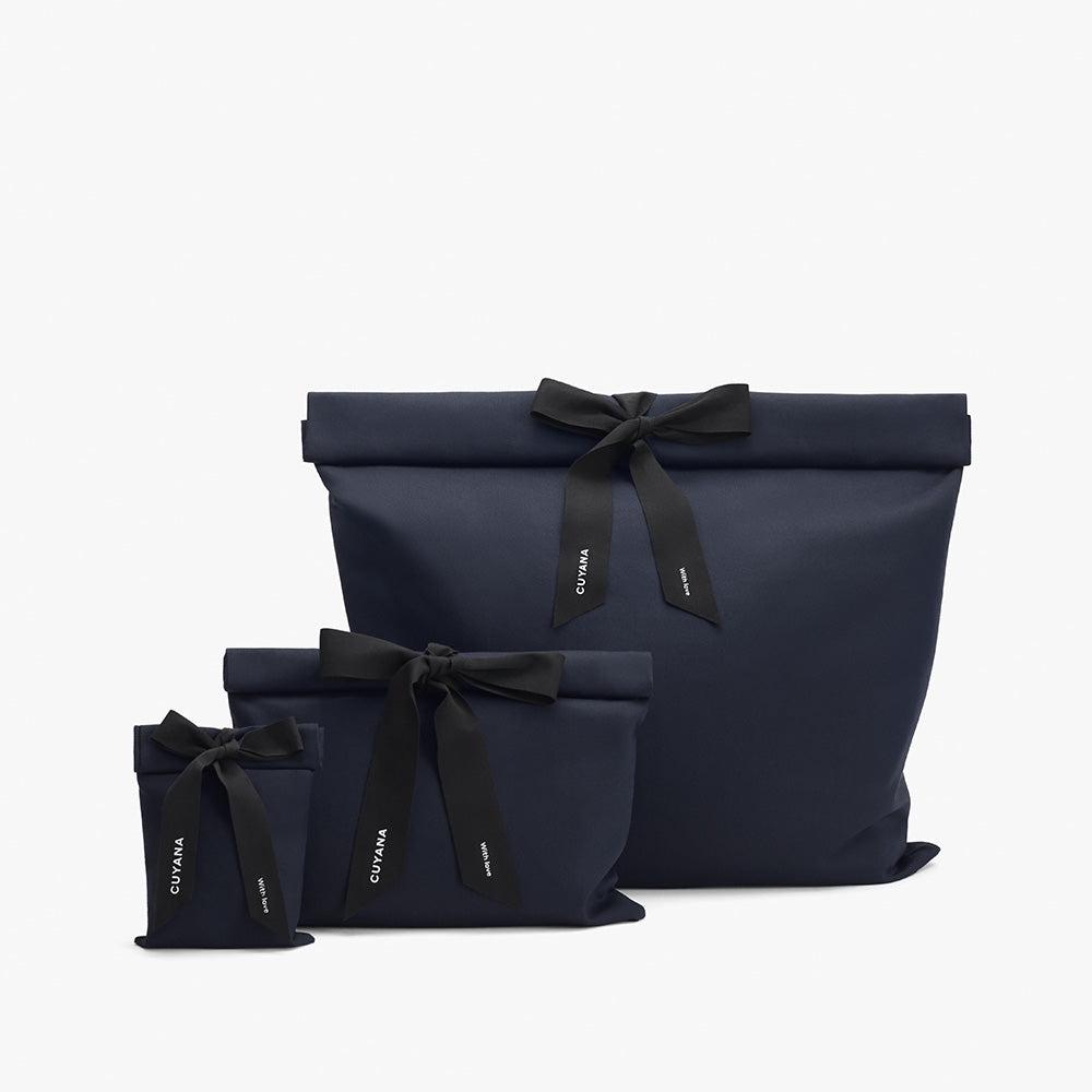 Three gift bags with bows arranged in a line.