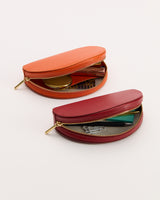 Two oval-shaped pouches with zippers, containing various small items.