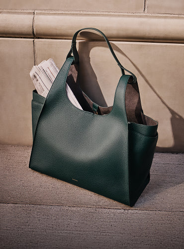 Large tote bag on pavement with papers sticking out