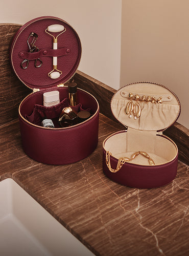 Jewelry and makeup cases open on a marble countertop