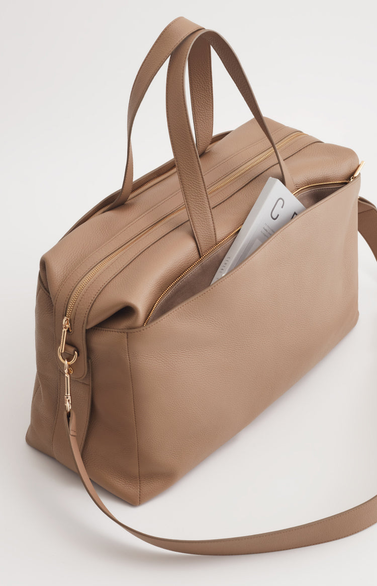 Handbag with a book partially sticking out.
