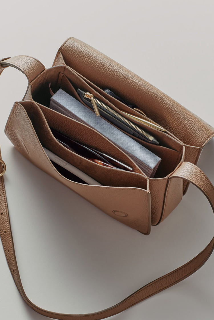 Open handbag with books and a notebook inside.