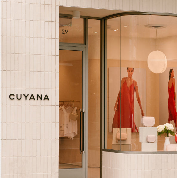 Storefront with a display window, images of a model, and store sign.