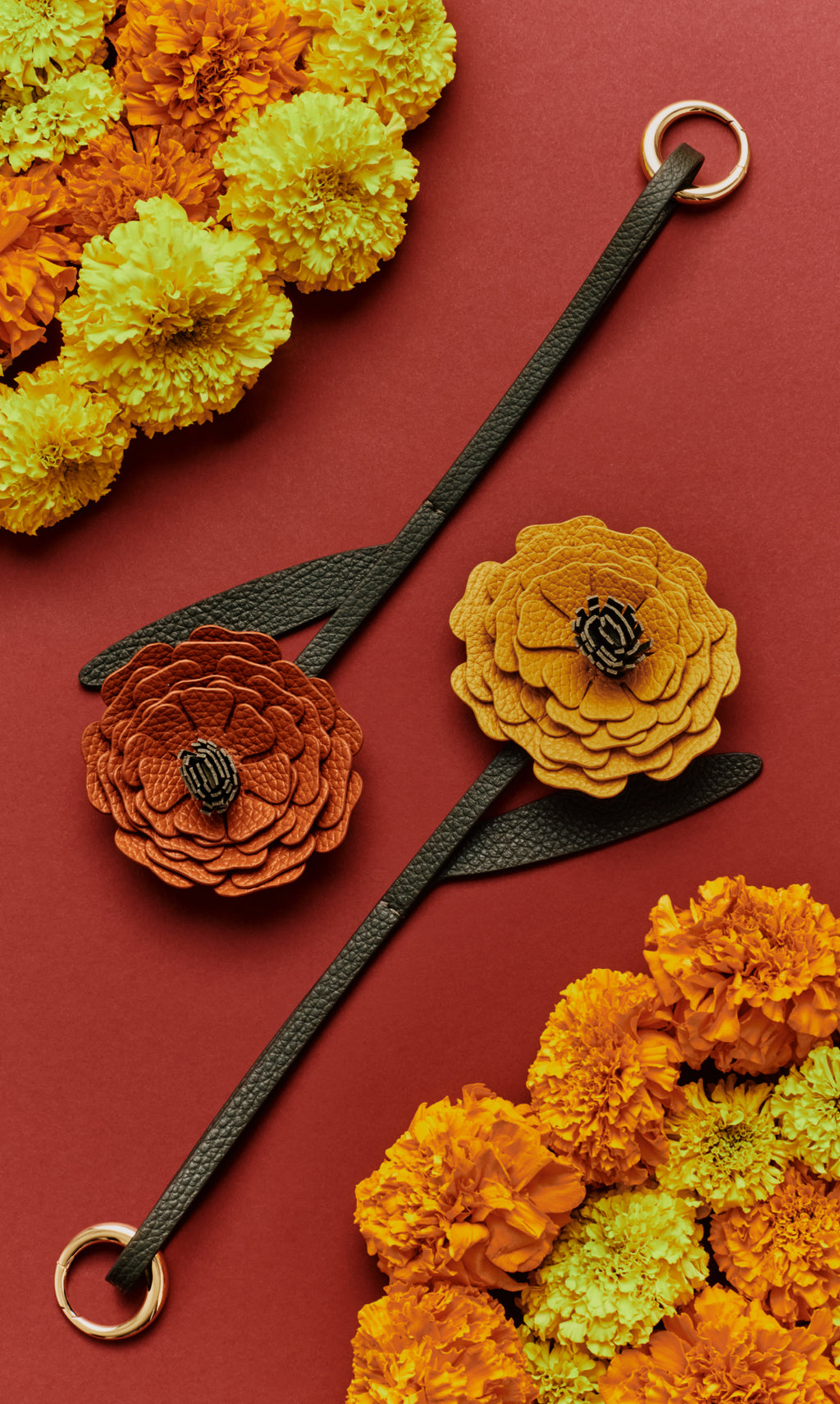 Two leather flower straps with marigolds on a flat surface.