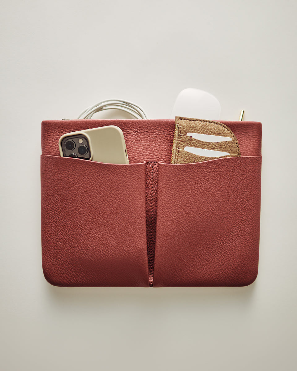 Organizer pouch with phone, cord, wallet, and small case inside.