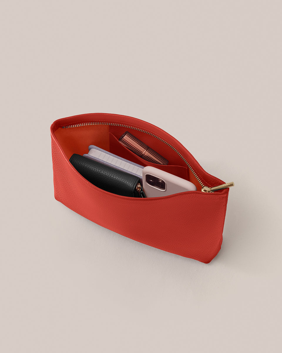 Open pouch with phone, wallet, and other small items inside.