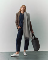 Person in suit with a scarf and a large tote bag.