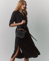 Woman in dress carrying a small shoulder bag