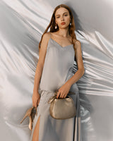 Woman standing with a handbag and high heels.