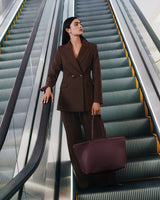 Person in a suit holding a large bag on an escalator