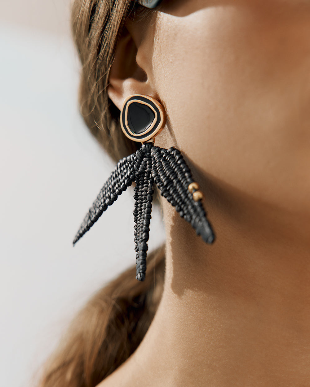 Earrings with beaded tassels worn by person