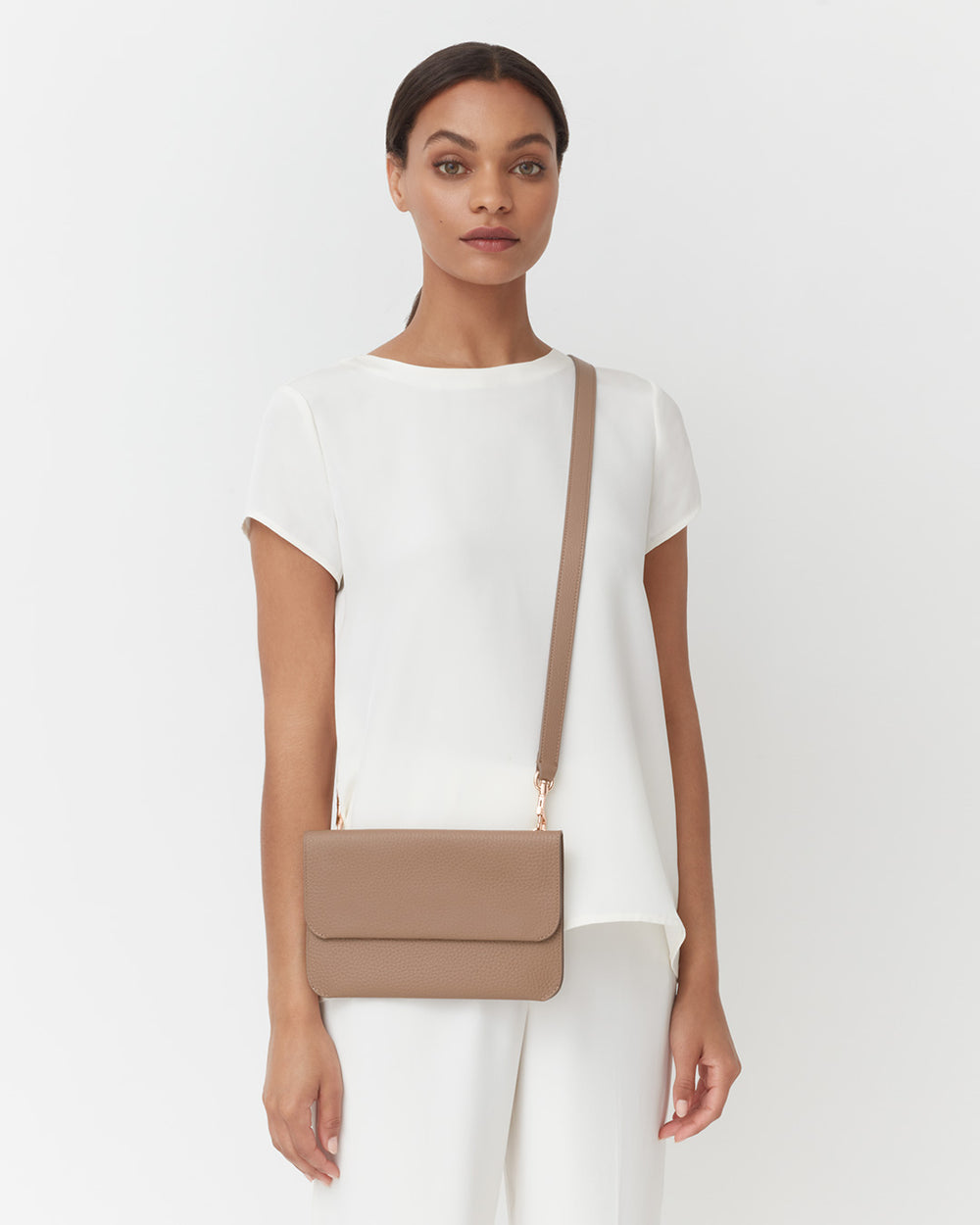 Woman standing with a crossbody bag