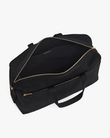 Open travel bag with zipper and handles on neutral background.