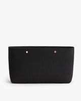 Black handbag with two front pockets and gold-tone rivets.